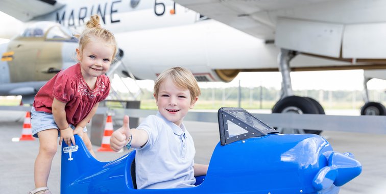 Zwei Kinder spielen mit Spielzeugflugzeug im Dornier Museum