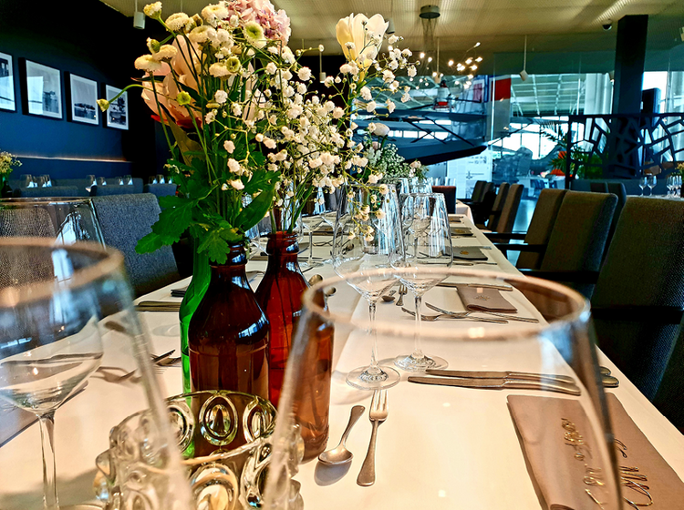 Festlich gedeckter Tisch mit Blumenschmuck Ein festlich gedeckter Tisch mit Blumenschmuck, zwei Weingläser stehen im Vordergrund.